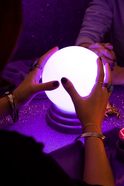 Free photo high angle woman holding crystal ball