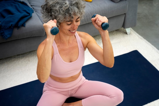 Free photo high angle woman holding dumbbells