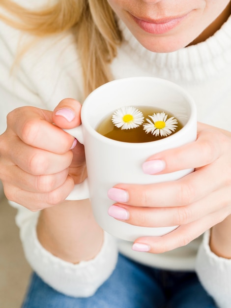 お茶とマグカップを保持しているハイアングルの女性