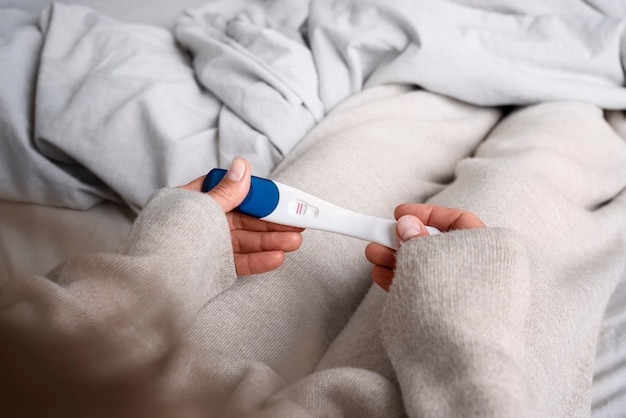 High angle woman holding positive pregnancy test