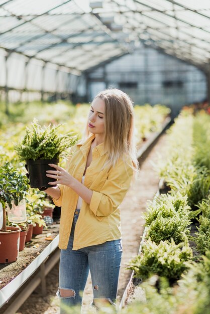 植物とポットを保持している高角度の女性