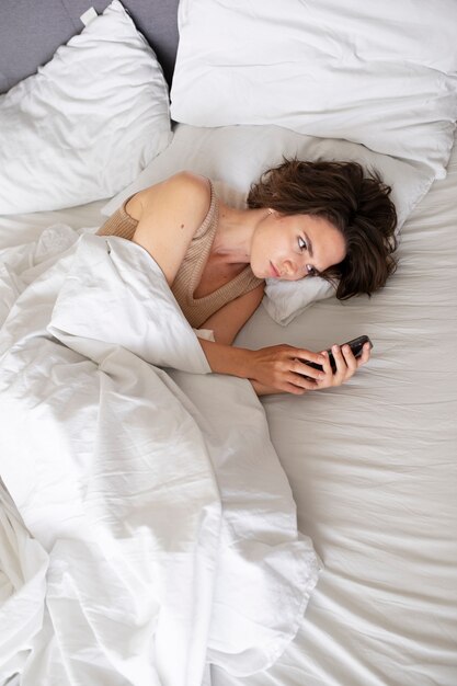 スマートフォンを握っている高角度の女性