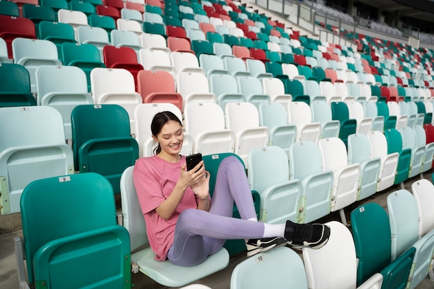 Foto gratuita smartphone della holding della donna dell'angolo alto