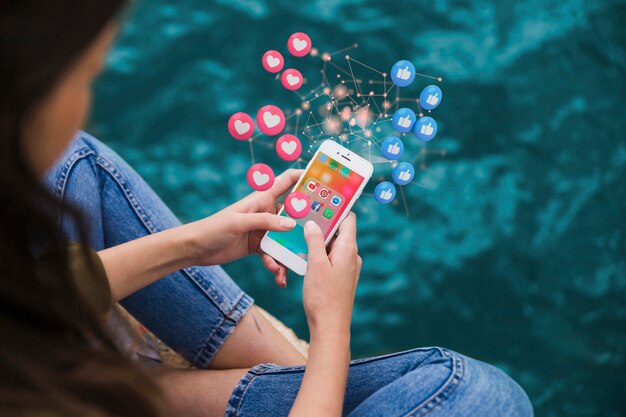 Женщина под высоким углом держит смартфон