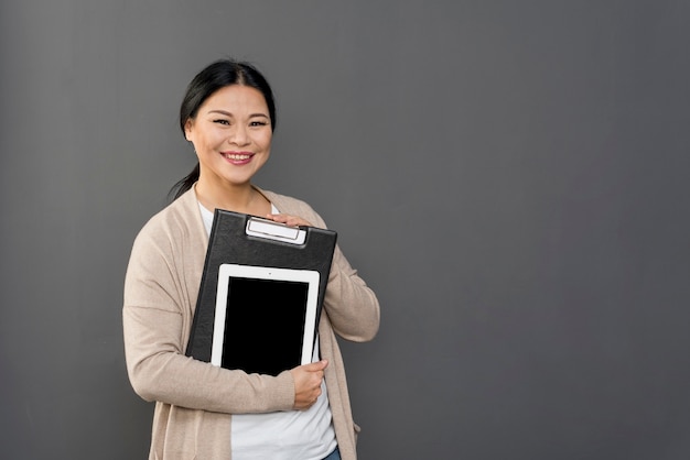 High angle woman holding tablet and clipboard