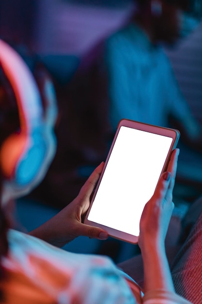 ヘッドフォンとタブレットを使用して自宅で女性の高角度