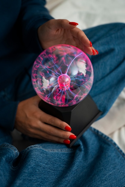 Free photo high angle woman interacting with a plasma ball