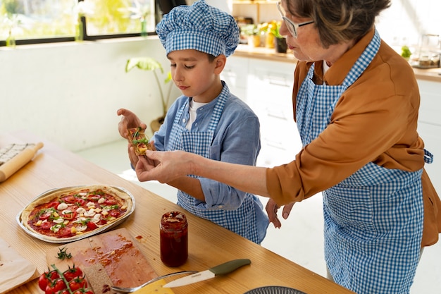 Free photo high angle woman and kid cooking together