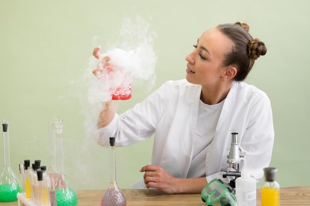 Foto gratuita donna dell'angolo alto in laboratorio che fa esperimento