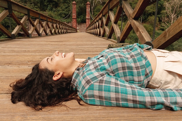 Foto gratuita donna dell'angolo alto posta sul ponte