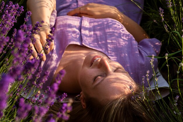 Женщина под высоким углом лежит в лавандовом поле