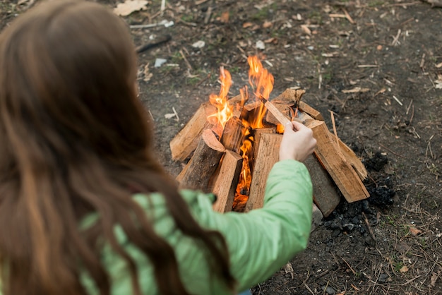 Free photo high angle woman making bonfire