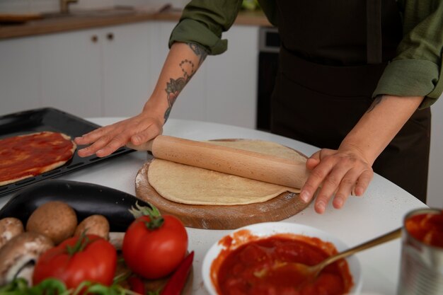Женщина под высоким углом готовит пиццу