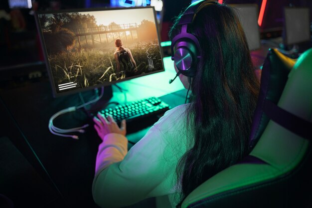 Женщина под высоким углом играет в видеоигры на компьютере