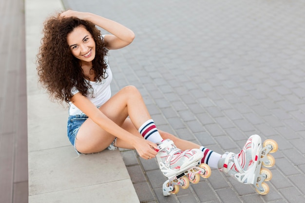 High angle woman posing with roller blades