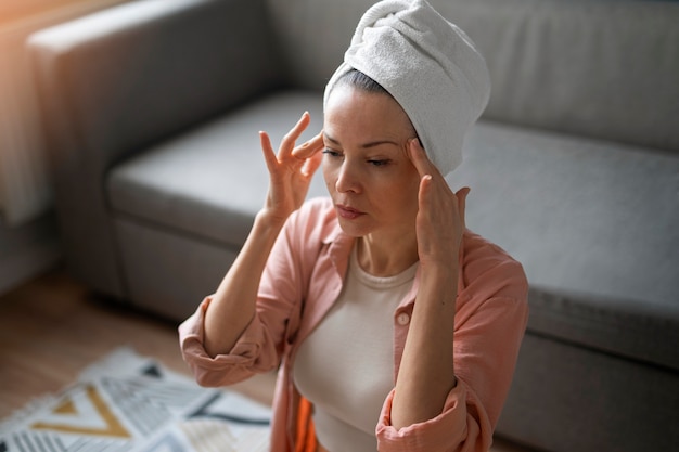 Free photo high angle woman practicing facial yoga