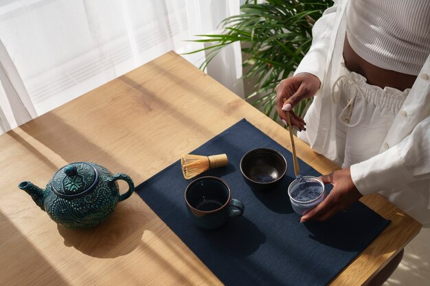 High angle woman preparing blue matcha at home