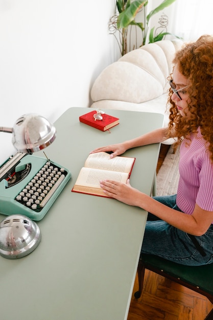 Free photo high angle woman reading at home