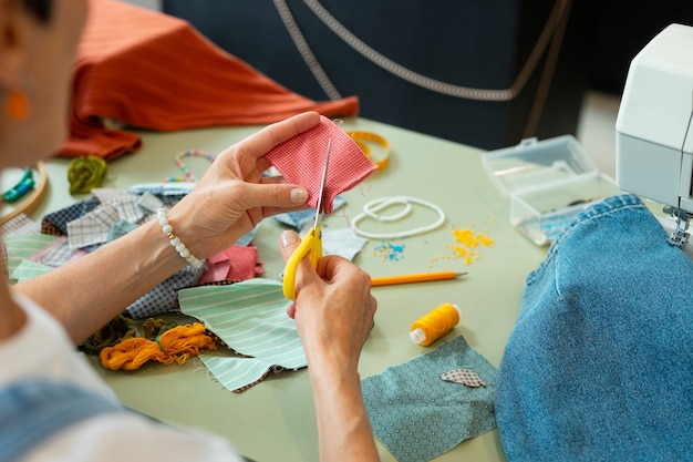 Free photo high angle woman repairing fashion goods