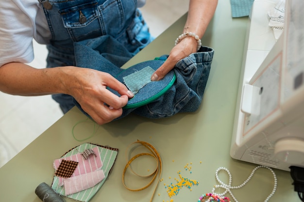 Free photo high angle woman repairing fashion goods