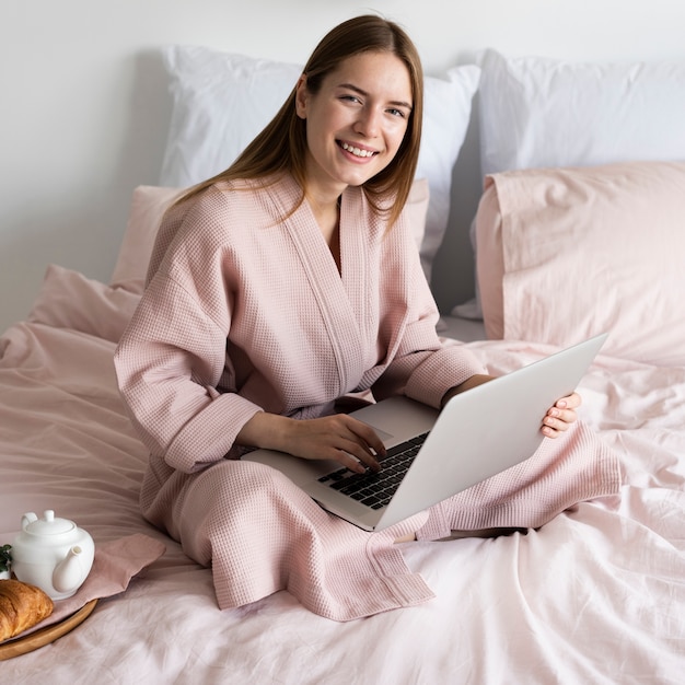High angle woman in robe checking her laptop