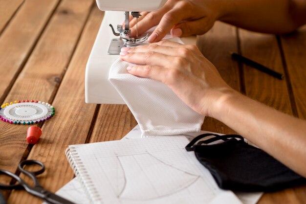 High angle of woman sewing face mask