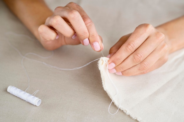 High angle of woman sewing textile