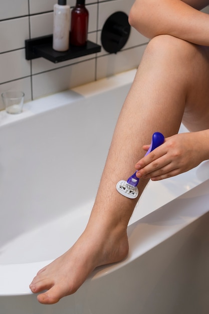 Free photo high angle woman shaving at home