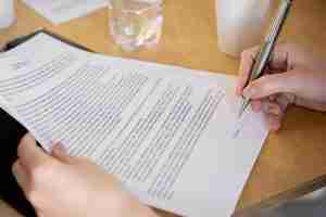 Free photo high angle woman signing document