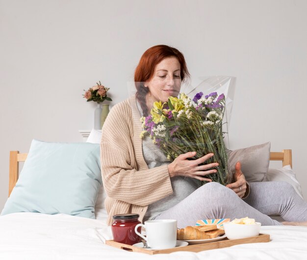 High angle woman smelling flowers bouquet