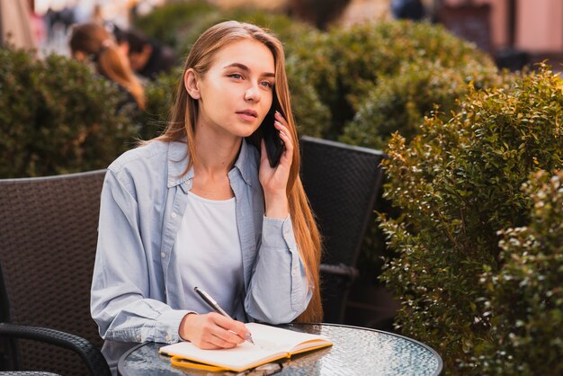 High angle woman taking notes in agenda