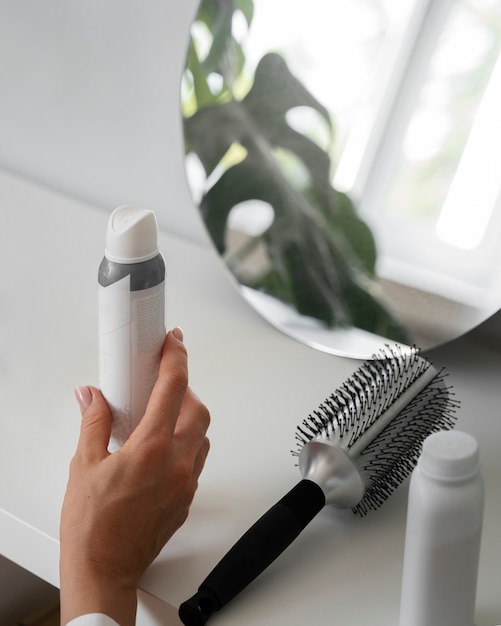 Free photo high angle woman using dry shampoo at home