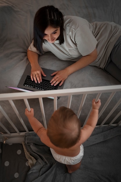 노트북에서 작업 하는 아기와 높은 각도 여자