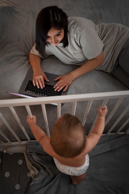 High angle woman with baby working on laptop