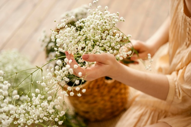 繊細な春の花のバスケットを持つ女性の高角度