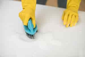 Free photo high angle of woman with cleaning gloves using brush