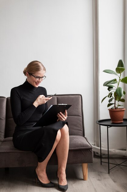 High angle woman with clipboard on couch