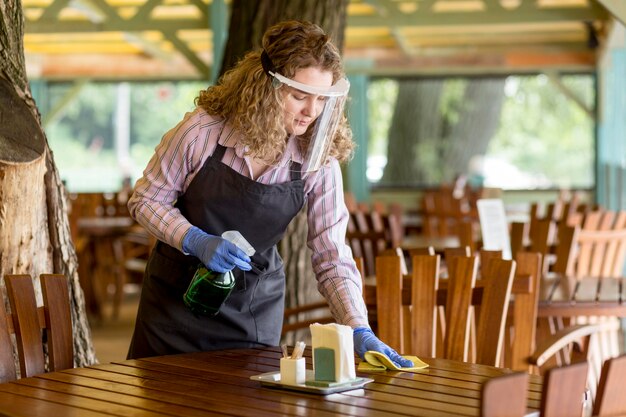 High angle woman with face protection cleaning