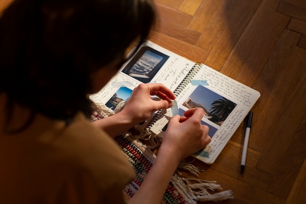 Foto gratuita donna dell'angolo alto con il diario a casa