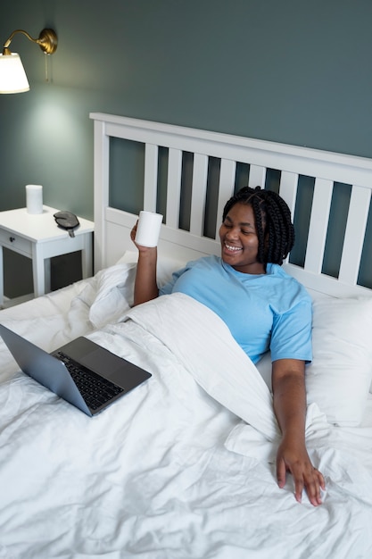 High angle  woman with laptop in bed