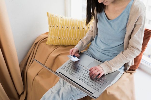 Foto gratuita alto angolo di donna con laptop e carta di credito