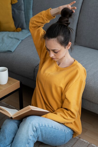 high angle woman with messy bun reading