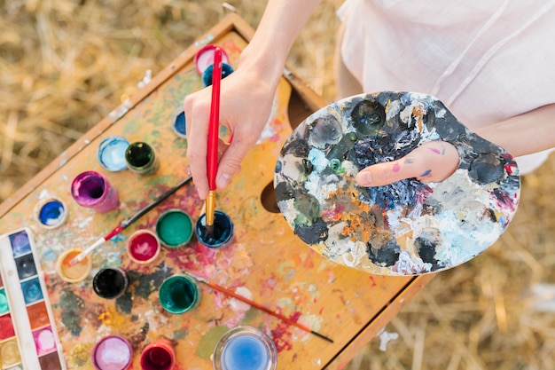 Foto gratuita donna dell'angolo alto con gli elementi della pittura