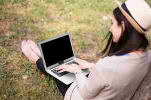 Free photo high angle of woman working on laptop outside