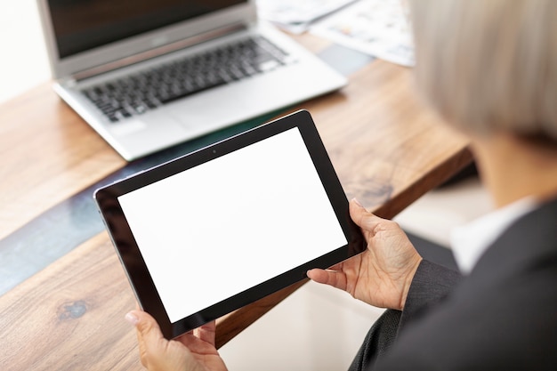 High angle woman working at office on tablet