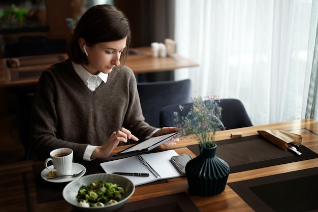 Free photo high angle woman working with tablet