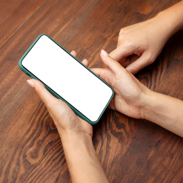 High angle of women hands holding smartphone