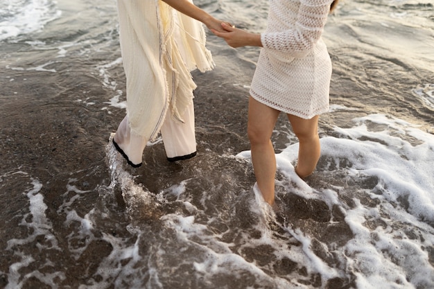 High angle women holding hands at seaside