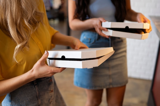 High angle women holding pizza