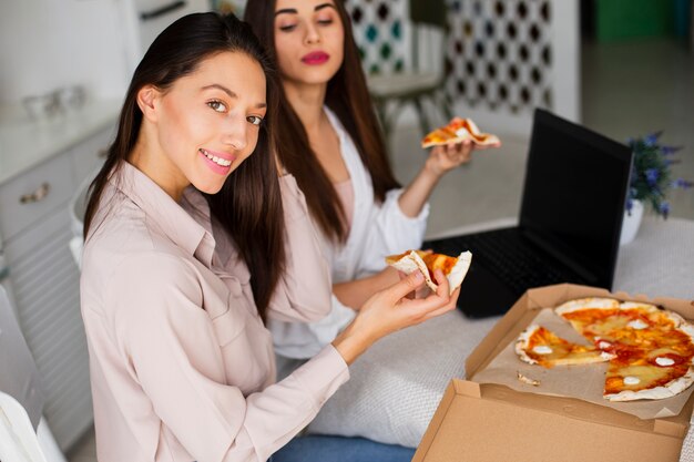 High angle women looking at camera while eating